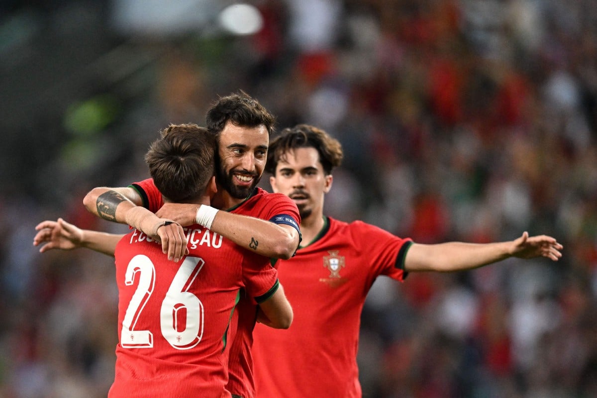 FERNANDES meraikan kejayaan bersama rakan pasukan selepas meledak gol buat Portugal. -FOTO AFP 