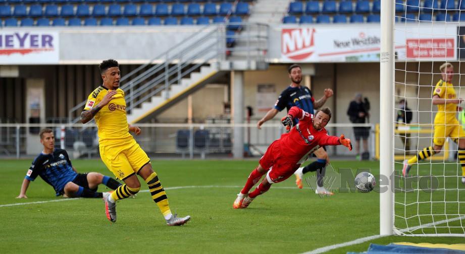 SANCHO (kiri) meledakkan gol kedua peribadinya menewaskan penjaga gol Paderborn, Zingerle di Banteler Arena awal pagi tadi. FOTO AFP