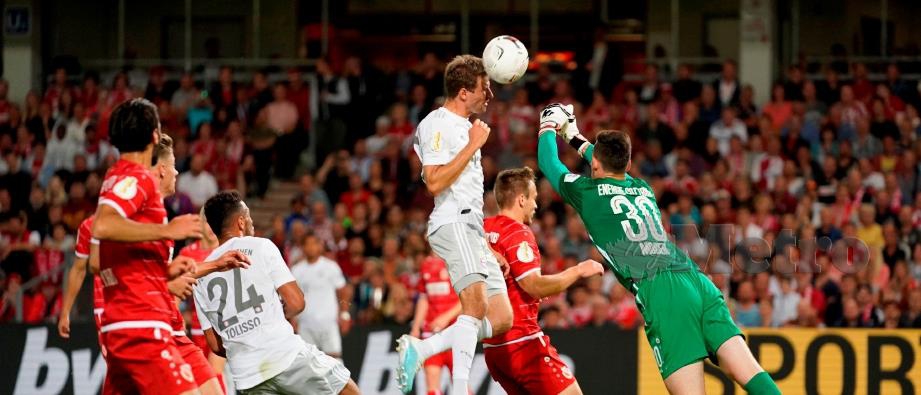 PENJAGA gol Cottbus,   Lennart Moser  menyelamatkan gawangnya daripada ditembusi penyerang  Bayern Munich, Thomas Mueller  di Stadium Freundschaft,   Cottbus. - FOTO AFP