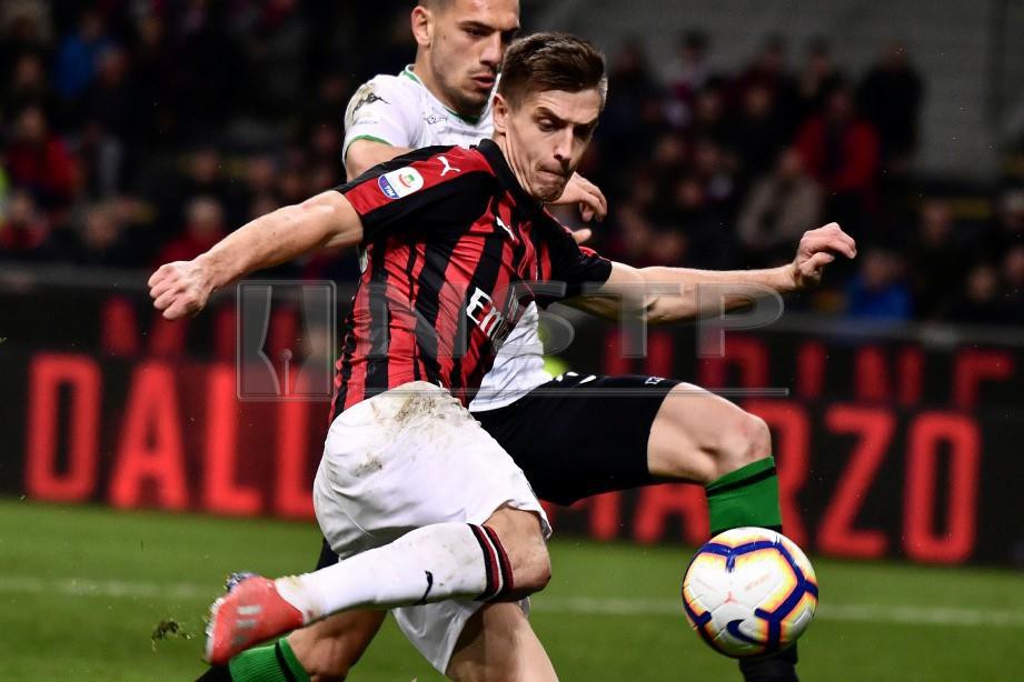  Penyerang AC Milan Krzysztof Piatek cuba melakukan rembatan sambil diasak pertahanan Sassuolo Merih Demiral dalam saingan Serie A Itali. FOTO AFP.
