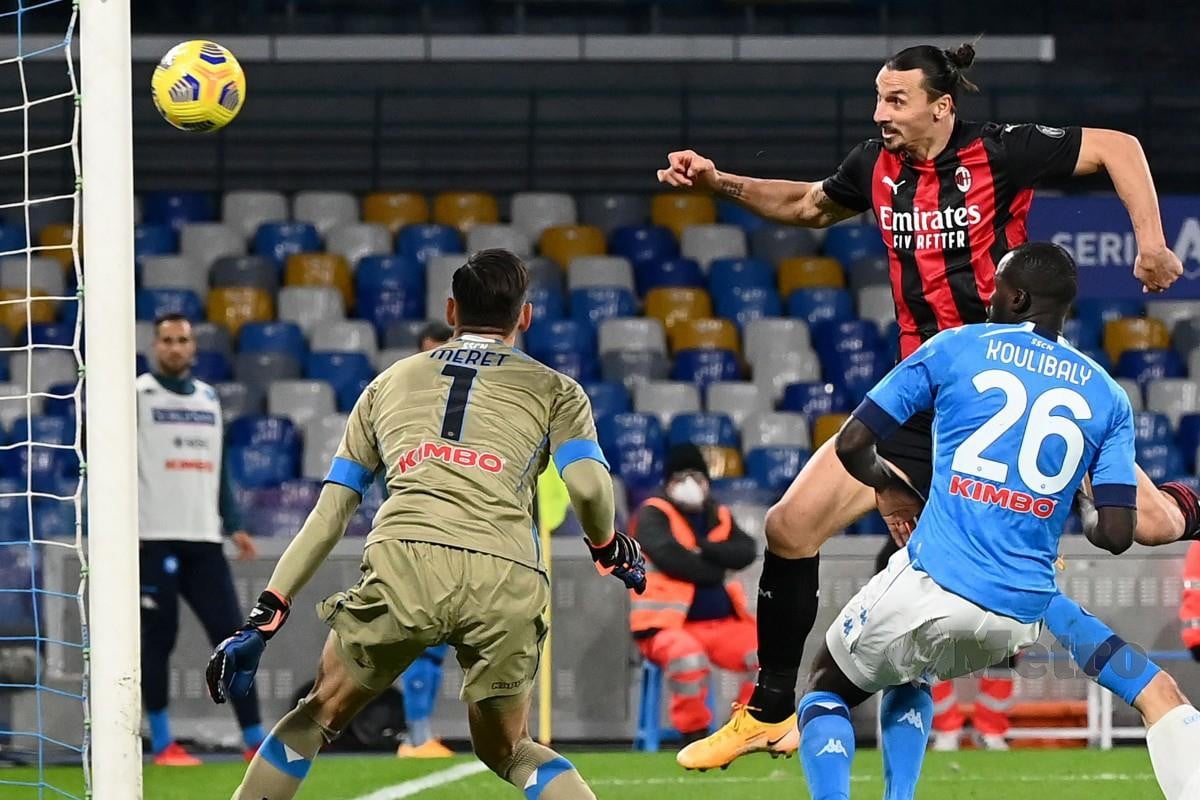 Penyerang AC Milan, Zlatan Ibrahimovic (atas kanan) menanduk gol mengatasi penjaga gol Napoli, Alex Meret (kiri) pada aksi Serie A. FOTO AFP