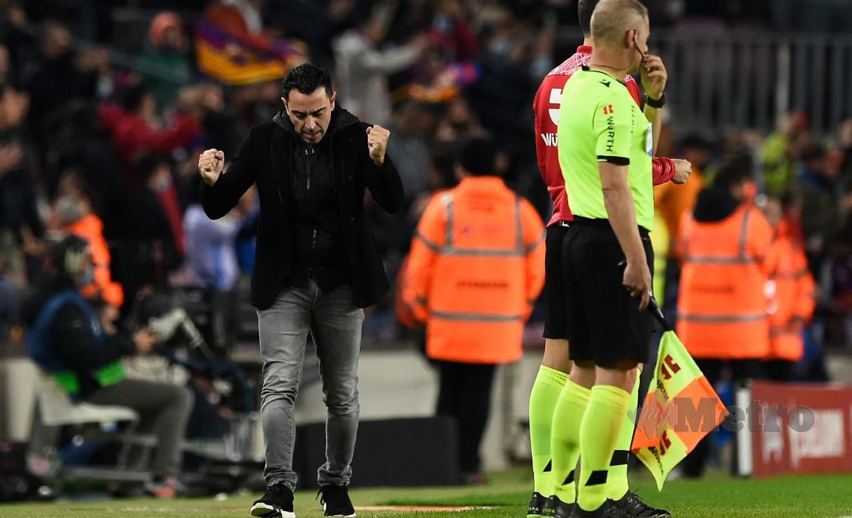 XAVI (kiri) puas selepas Barca berjaya mencatat kemenangan dalam penampilan pertamanya sebagai pengurus. FOTO AFP