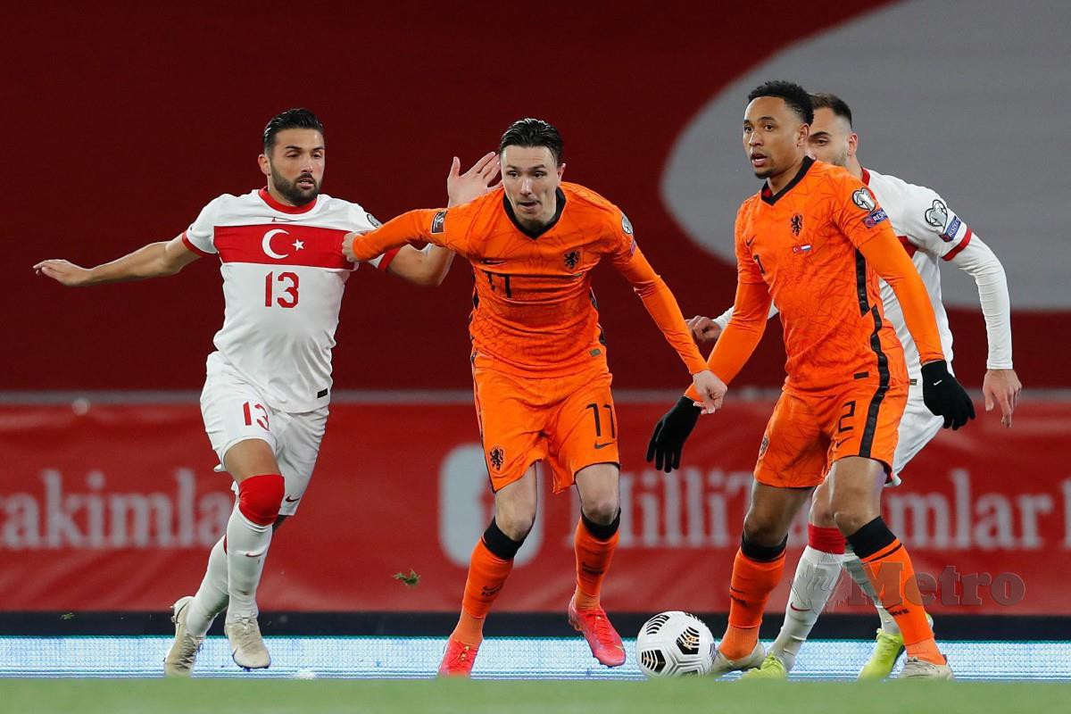 PENYERANG Belanda, Steven Berghuis (tengah) mengawal bola melepasi pertahanan Turki, Umut Meras (kiri) pada perlawanan hari ini. FOTO AFP