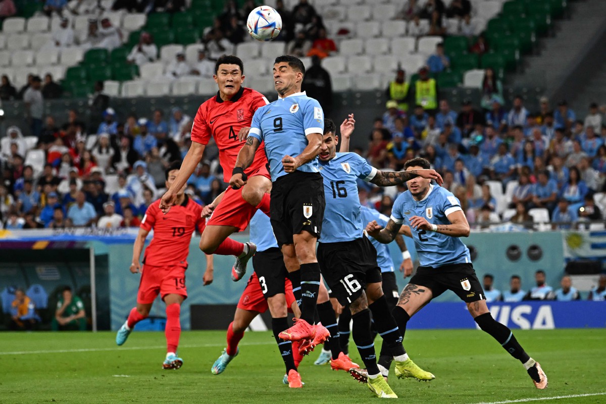 Penyerang Uruguay, Luis Suarez dicabar pemain Korea Selatan pada aksi Piala Dunia. FOTO AFP