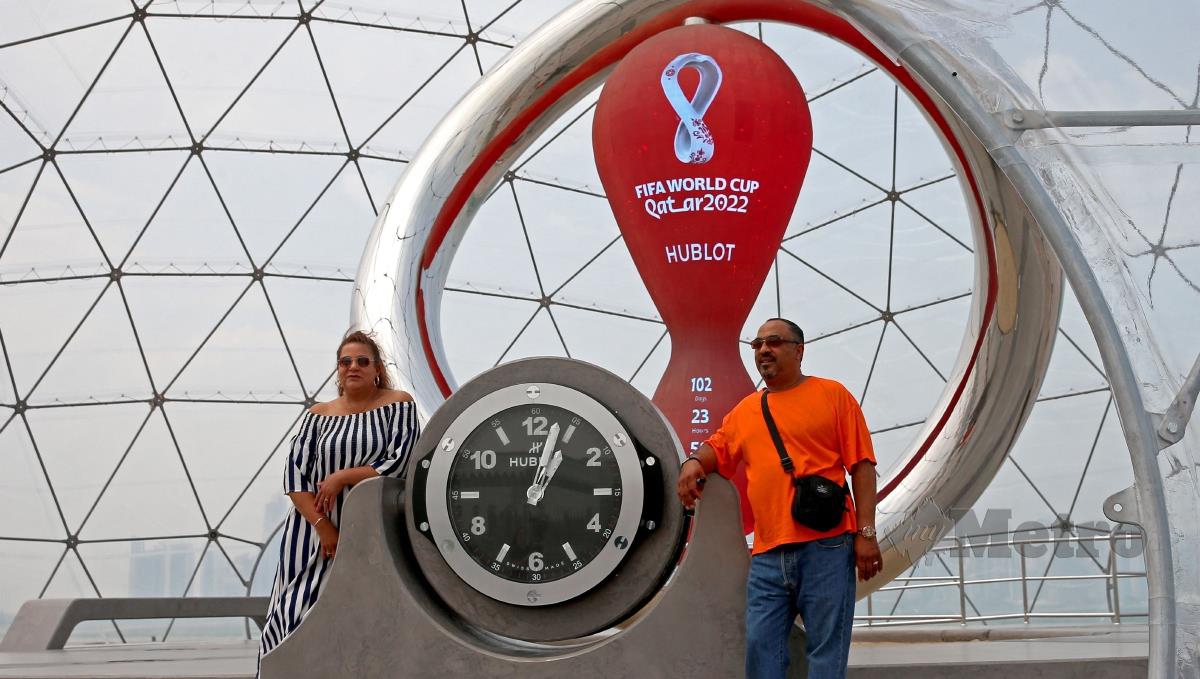 ORANG ramai bergambar dengan jam kira detik menjelang Piala Dunia Qatar 2022 di Doha. FOTO AFP