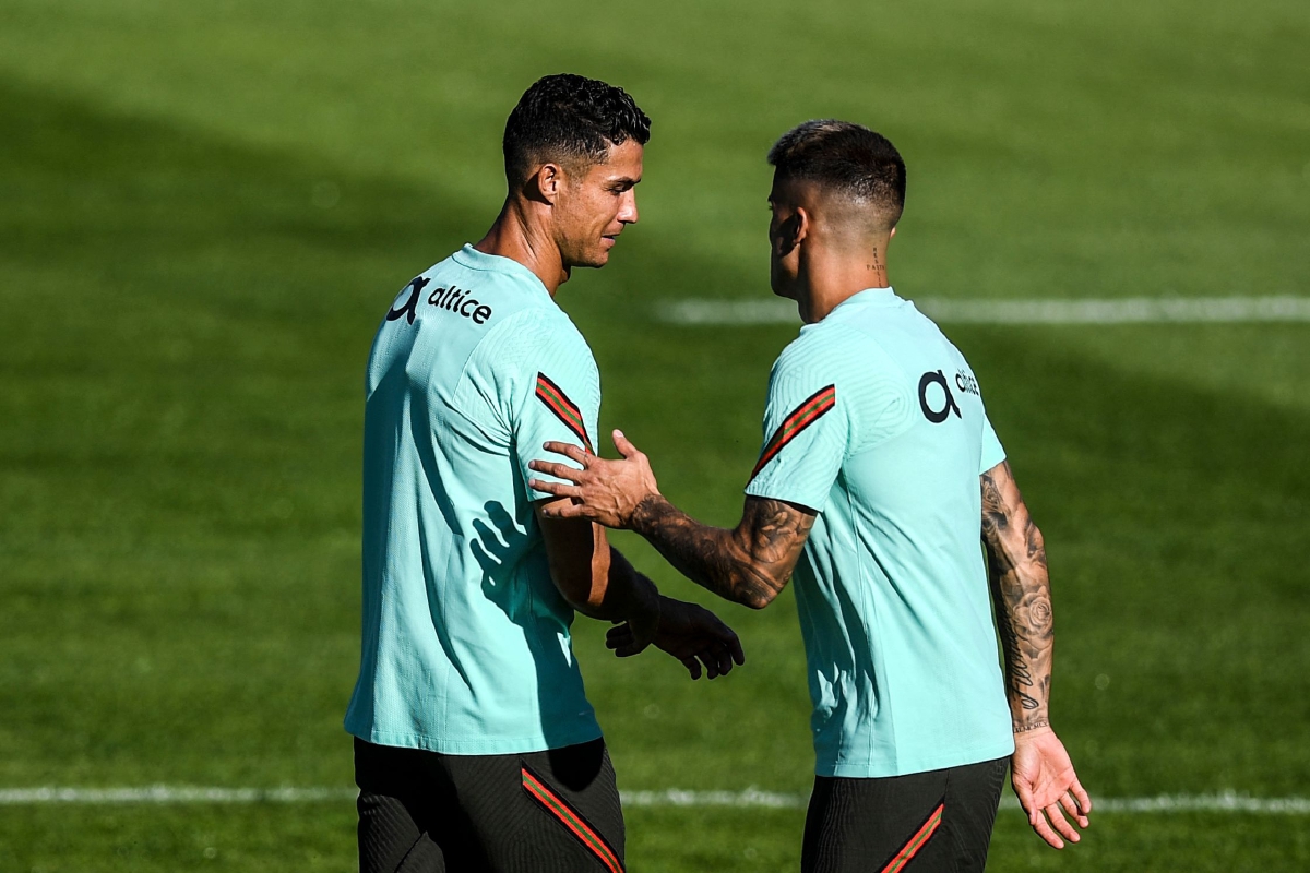 RONALDO (kiri) dan Cancelo memanaskan badan di Lisbon. FOTO AFP 