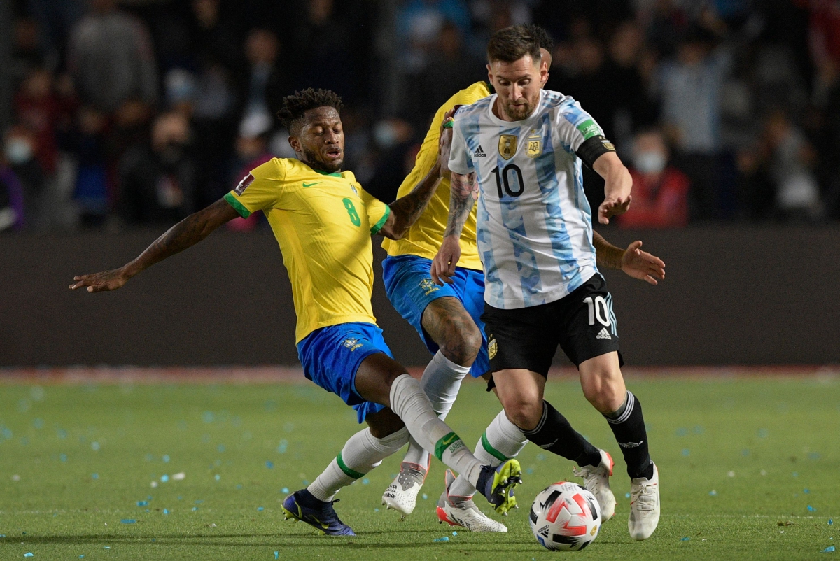 MESSI  diasak dua pemain Brazil dalam perlawanan di San Juan, Argentina.