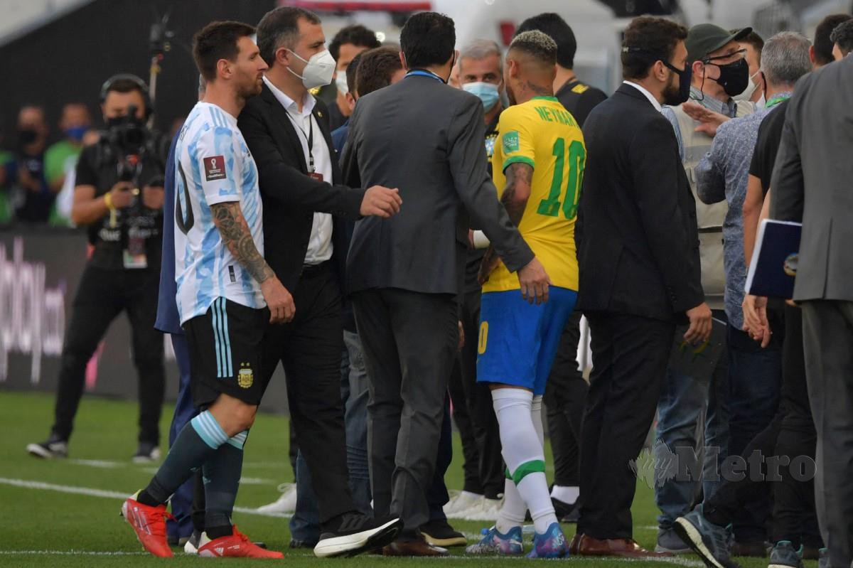 LIONEL Messi (L) dan Neymar cuba untuk menghalang tindakan pegawai keselamatan Brazil. FOTO AFP 