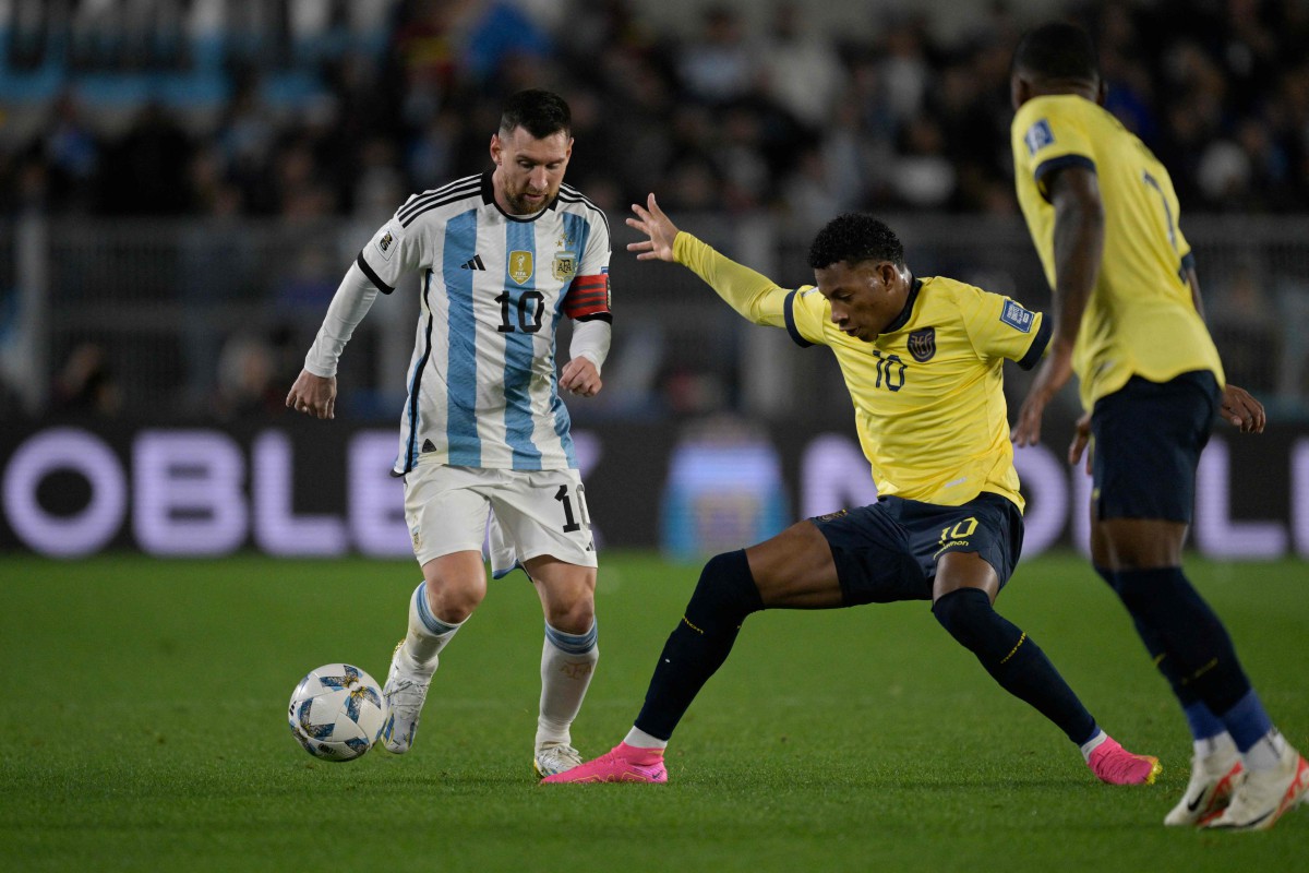 MESSI (kiri) mengawal bola melepasi kawalan pemain tengah Ecuador, Gonzalo Plata (tengah). -FOTO AFP 