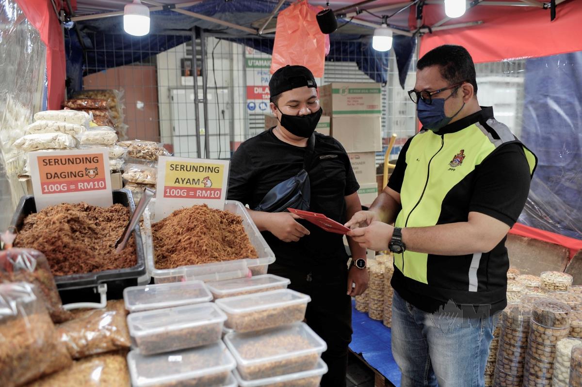 Pengarah Jabatan Pelesenan dan Pembangunan Perniagaan DBKL, Khairul Anuar Mhd Juri memeriksa lesen peniaga yang berniaga di Bazar Ramadan di Lorong Tuanku Abdul Rahman, Kuala Lumpur. FOTO AIZUDDIN SAAD