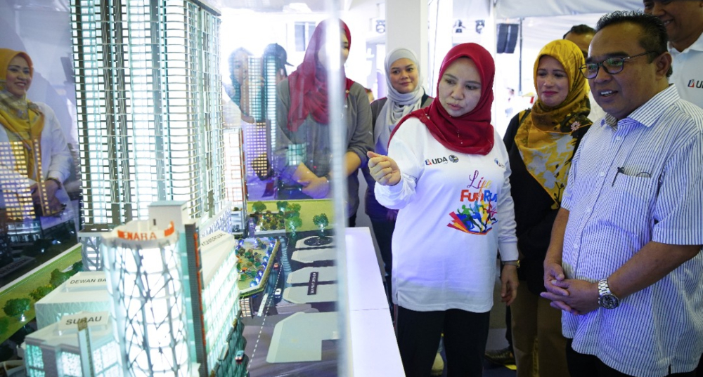 NORLIZA (tiga dari kanan) berkunjung ke gerai pameran hartanah UDA di Karnival UDA USHAniaga Keluarga Malaysia.