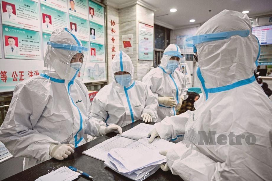 Kakitangan perubatan memakai sut keselamatan di Wuhan. FOTO AFP