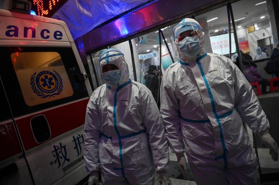KAKITANGAN perubatan memakai sut keselamatan di hospital di Wuhan. FOTO AFP 
