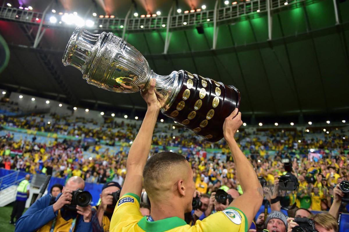 PEMAIN Brazil, Richarlison menjulang trofi Copa Amerika pada Julai 2019 di Stadium Maracana dekat Rio de Janeiro. FOTO AFP