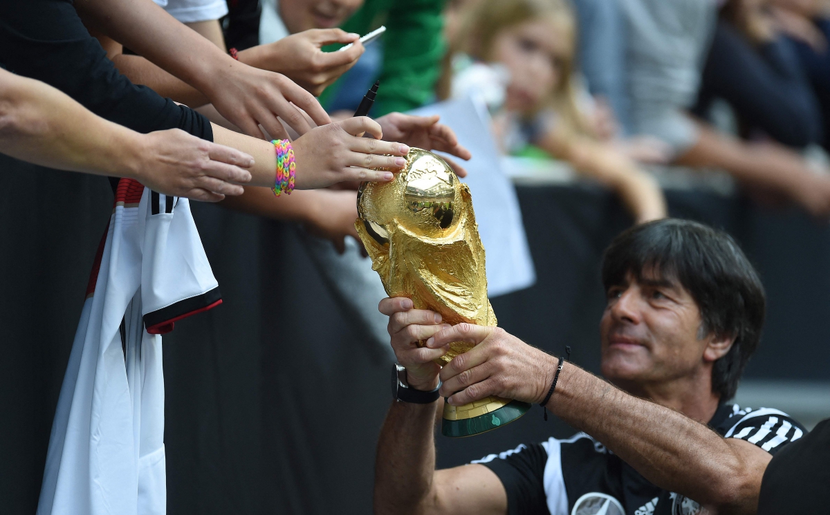LOEW bersama trofi Piala Dunia 2014. FOTO AFP
