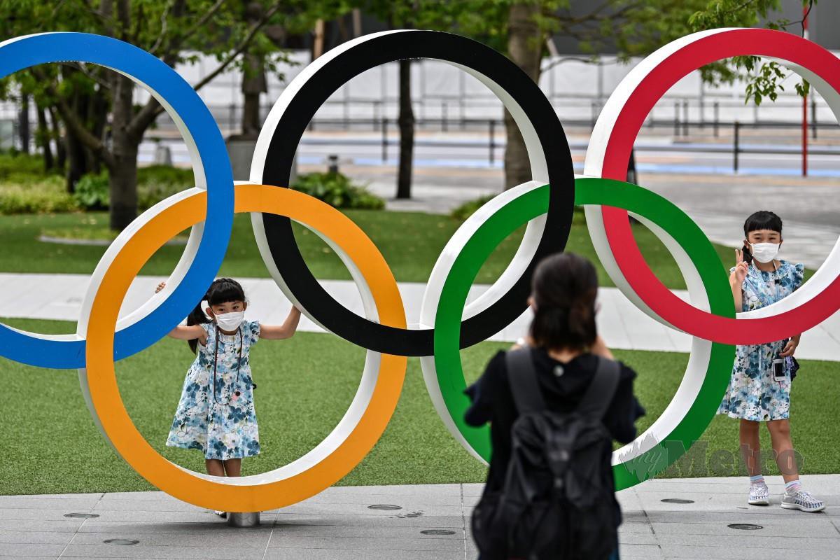 Beberapa penduduk merakamkan gambar di hadapan replika Olimpik di Tokyo. FOTO AFP