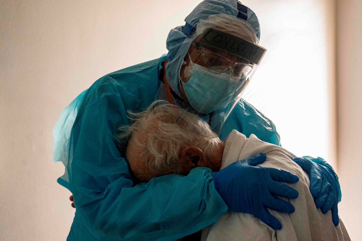FOTO tular Varon memeluk pesakit tua di sebuah hospital di Texas. FOTO Getty Images North America / AFP. 