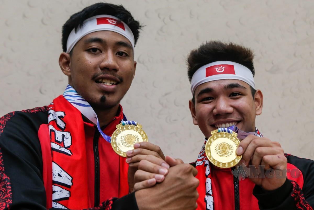 MING Hock (kanan) dan Amir Amirul memenangi emas acara skuasy beregu lelaki selepas menewaskan pasukan Kedah. FOTO HAZREEN MOHAMAD