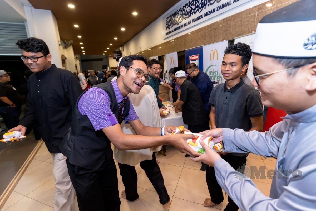 KAKITANGAN  McDonald’s Malaysia mengagihkan makanan untuk program Misi Moreh Mekdi.     
