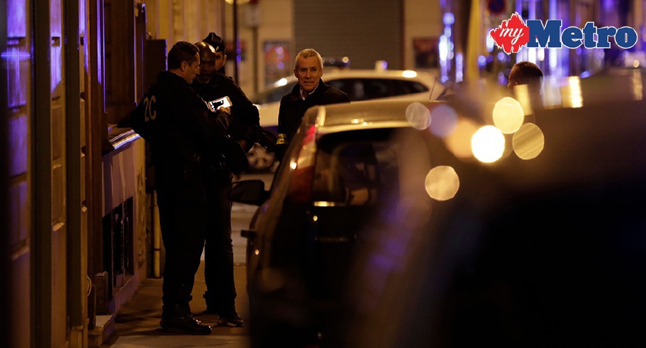 MORLINS (kanan) bersama anggota polis lain melihat tempat kejadian. FOTO/AFP  