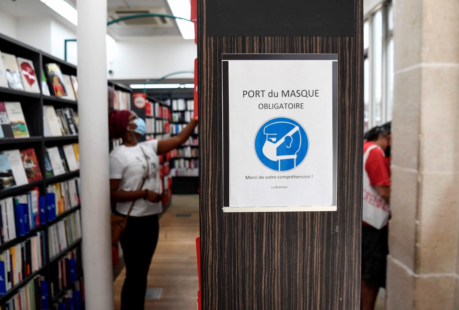 FOTO menunjukkan notis peringatan supaya orang ramai memakai pelitup muka di sebuah kedai buku dan mutimedia di Paris. FOTO AFP 