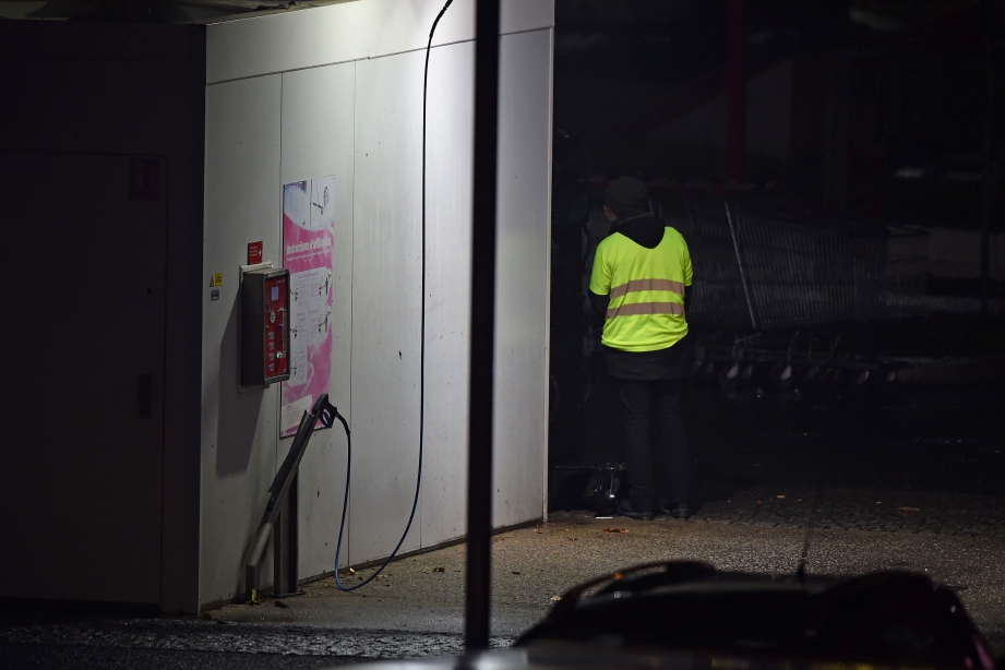 LELAKI yang memakai ‘jaket letupan kuning’ dan mengancam untuk meletupkan bom tangan di sebuah stesen minyak. FOTO AFP