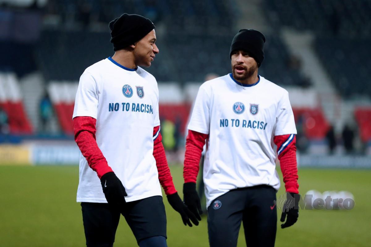 Bintang PSG, Kylian Mbappe (kiri) dan Neymar memakai kemeja-T memperagakan tulisan ‘tidak kepada perkauman’. FOTO Agensi