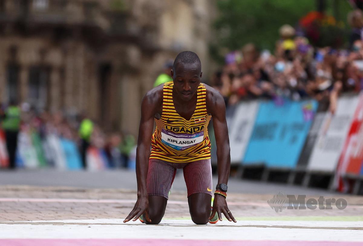 ATLET Uganda, Victor Kiplangat melutut selepas menang emas maraton lelaki walaupun tersalah jalan di Birmingham 2022. FOTO REUTERS 