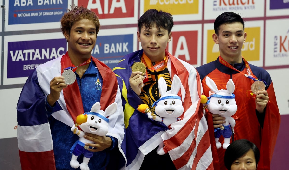 HOE Yean (tengah) diapit pemenang pingat perak daripada Thailand dan perenang Vietnam yang meraih gangsa. FOTO Reuters