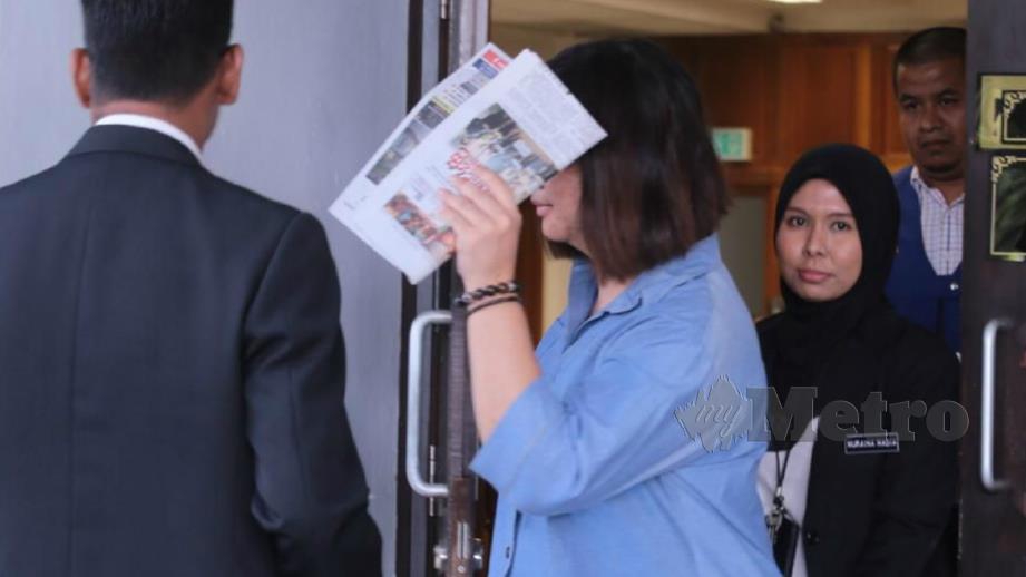 LAI menutup muka menggunakan surat khabar. FOTO Muhammad Zuhairi Zuber.