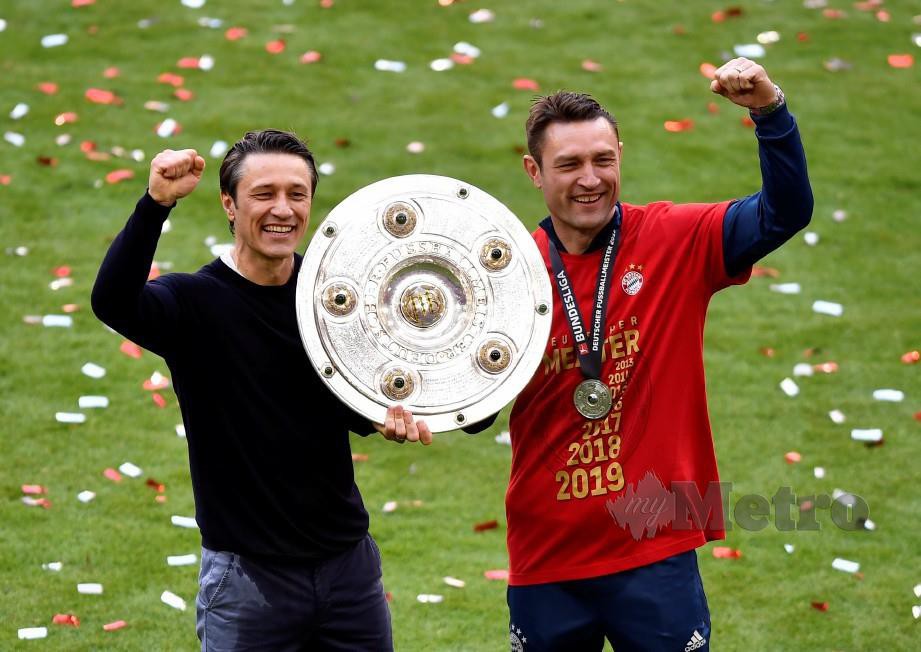 Ketua Jurulatih Bayern Niko Kovac (kiri) dan adiknya Robert Kovac meraikan trofi kejuaraan Bundesliga. FOTO EPA.