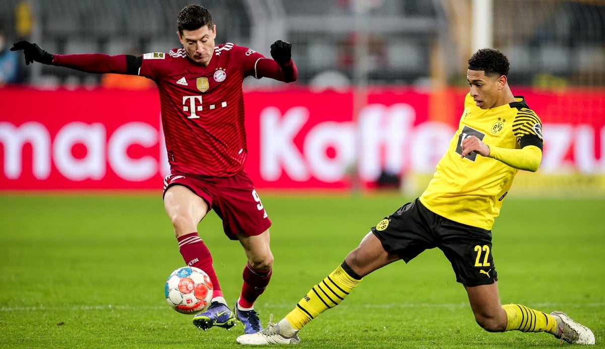 Pemain Dortmund, Jude Bellingham (kanan) cuba menghalang penyerang Bayern Robert Lewandowski pada aksi Bundesliga. FOTO EPA