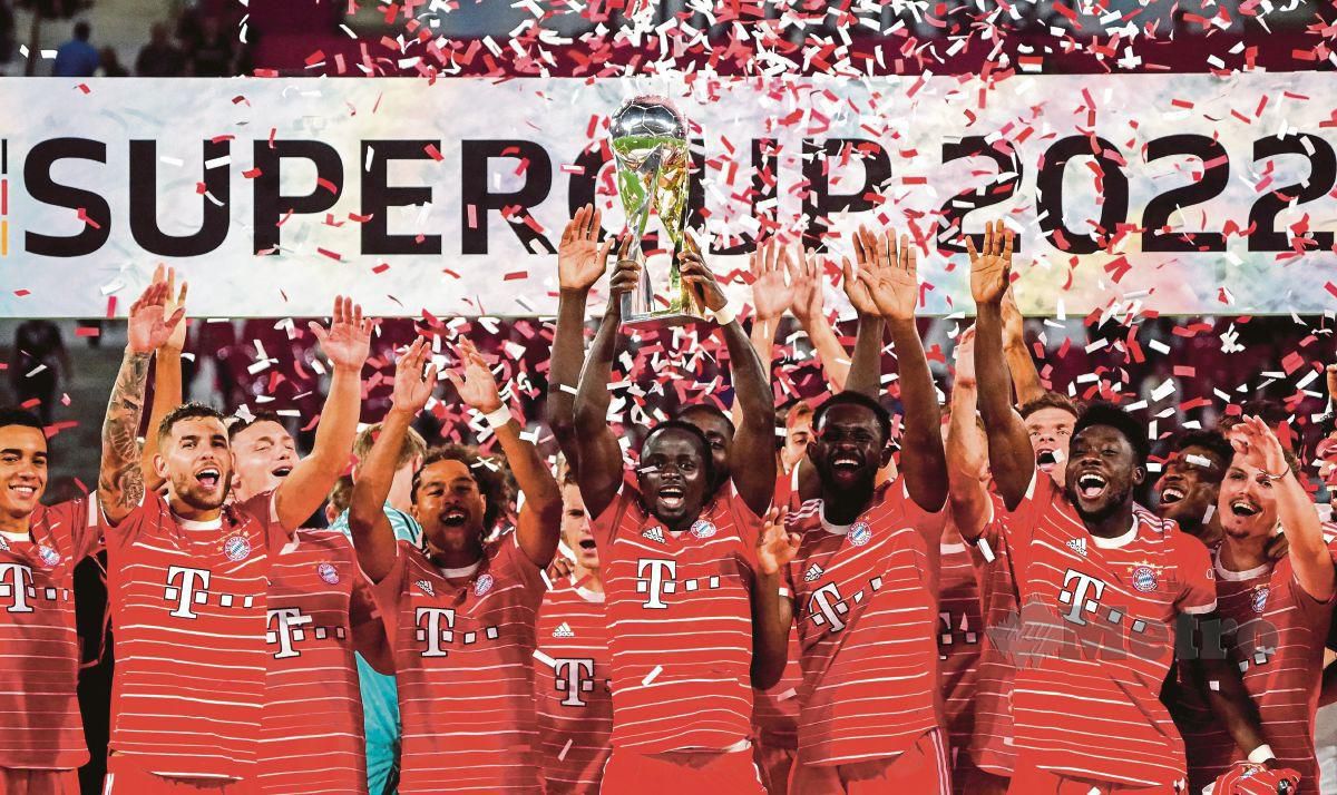 PEMAIN Bayern, Sadio Mane (tengah) menjulang trofi Piala Super Jerman selepas menang 5-3 ke atas RB Leipzig, malam tadi. FOTO EPA 