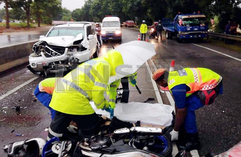 ANGGOTA polis dan Angkatan Pertahanan Awam Malaysia (APM) mengangkat mayat Goh selepas kemalangan membabitkan dua motosikal dan sebuah SUV di Lebuh Sungai Udang-Paya Rumput-Ayer Keroh (SPA) di Taman Paya Emas, Bertam Ulu, Melaka, hari ini. FOTO Rasul Azli Samad.