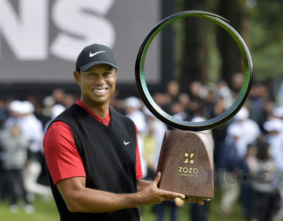 Tiger Woods memegang trofi Kejuaraan Zozo yang dimenangi di Jepun. FOTO Reuters