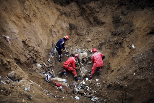 Anggota penyelamat mengalihkan tanah bagi mengeluarkan mayat mangsa yang tertimbus. - Foto REUTERS