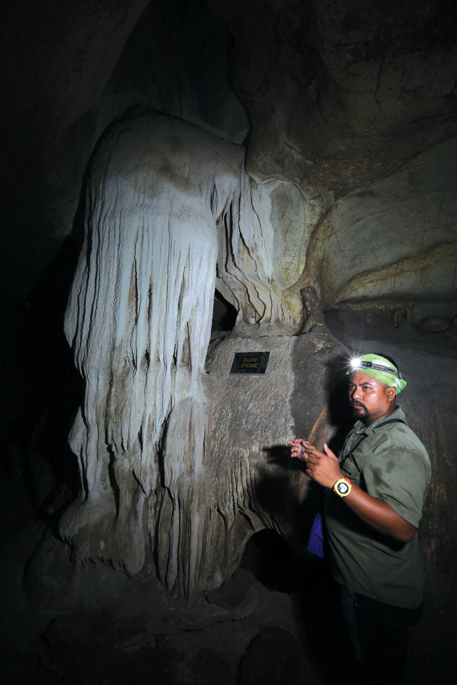 BUKHARI menerangkan mengenai batuan di gua kepada pengamal media.  FOTO: Aswadi Alias