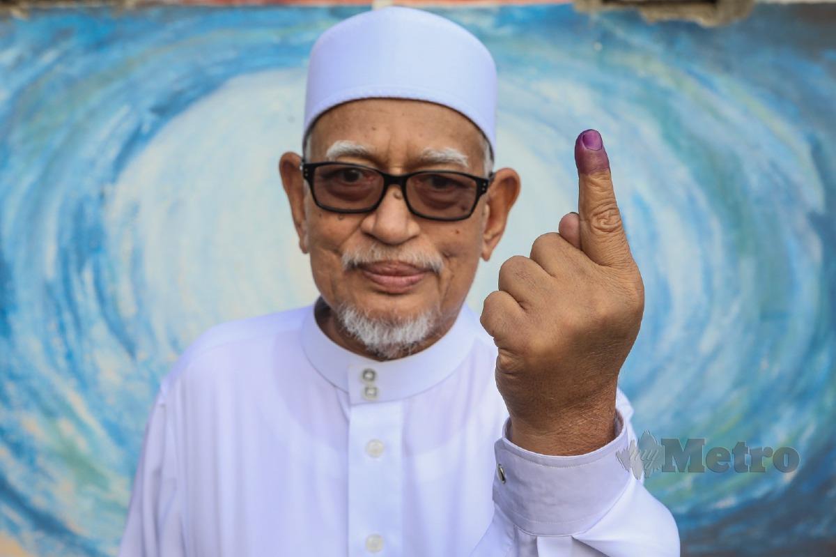 ABDUL Hadi Awang  menunjukkan jari yang dicelup dakwat kekal selepas mengundi bagi Pilihan Raya Negeri (PRN) di Sekolah Kebangsaan (SK) Rusila, Marang. FOTO Ghazali Kori