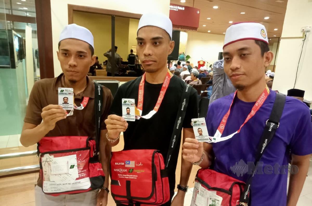 Muhammad Nazirul Haqimi (tengah), Muhammad Nazirul Fatihi (kanan) dan Muhammad Nazirul Hazimi (kiri) menunjukkan kad nama haji di stesen haji LTSM, semalam. FOTO BAHAROM BAKAR.