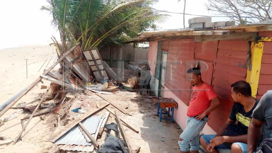 MOHD Mussahar (kiri) melihat kerosakan bahagian dapur rumahnya selepas kejadian ombak dan angin kencang melanda Kampung Nenasi Pantai, Pekan, malam tadi. FOTO Mohd Rafi Mamat.