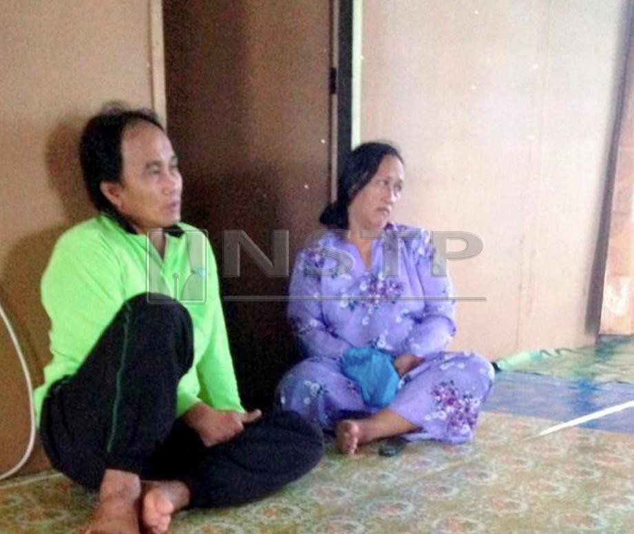 HALIMAH Geronggong, 42, (kanan) bersama suaminya, Ali Bengang, 53, menerima berita kematian anaknya dengan tenang dan redha di Kampung Tian Matu, Mukah. FOTO Khalid Latip