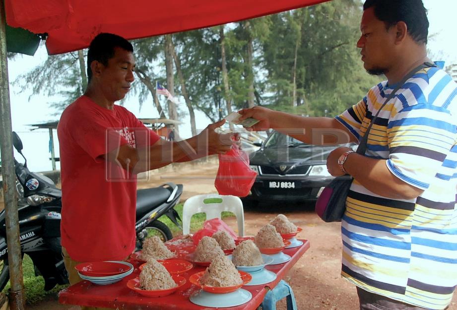 MOHAMAD (kiri) menjual geragau kepada Kamarul Nizam Mohd Khalid, 37, di Kampung Pantai Rombang, Pantai Puteri, Melaka, hari ini. FOTO Hasan Omar.