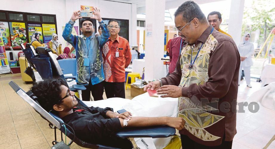 DR Saifur Rahman (kanan) melihat buku catatan derma darah semasa melawat penderma darah di Hari Bersama Pelanggan HSNZ di Kuala Terengganu, hari ini. FOTO Imran Makhzan.