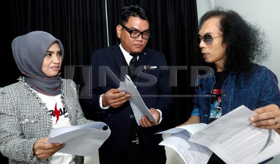 HATTA (kanan) bersama isteri, Azslender Abdul Aziz dan penguamnya, Faizul Mohd Nasir berbincang sesuatu pada sidang akhbar kes saman penganjur di Balai Berita. FOTO Halimaton Saadiah Sulaiman