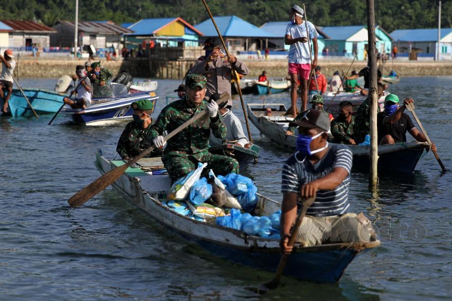 ANGGOTA tentera ketika Indonesia membantu penduduk setempat di Indonesia. FOTO AFP