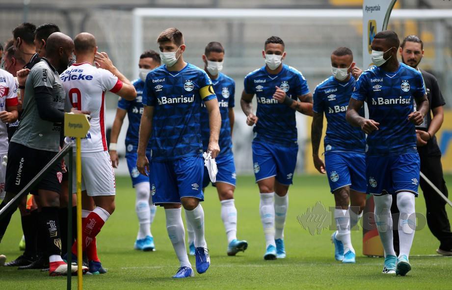 Soccer Football - Campeonato Gaucho - Gremio v Sao Luiz - Arena do Gremio, Porto Alegre, Brazil - March 15, 2020    Gremio players wearing masks before the match is played behind closed doors as the number of coronavirus cases grow around the world       REUTERS/Diego Vara