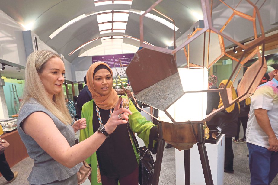 PENGUNJUNG melihat hiasan lampu lantai yang dipamerkan pada Pameran Semester Akhir Ijazah Sarjana Muda Seni Reka Logam Kontemporari di Galeri Seni Tuanku Nur Zahirah UiTM Shah Alam. 