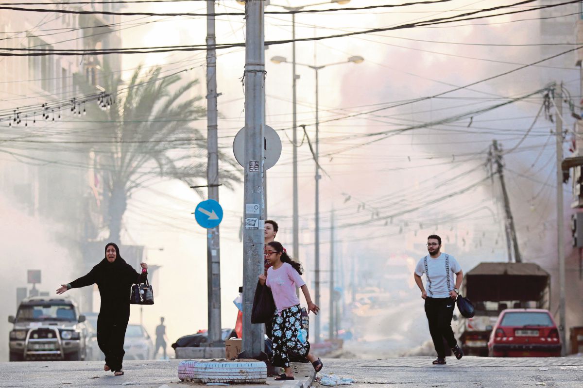 PENDUDUK Palestin mencari perlindungan ketika serangan udara Israel berhampiran Hospital Al-Shifa di Gaza. FOTO AFP