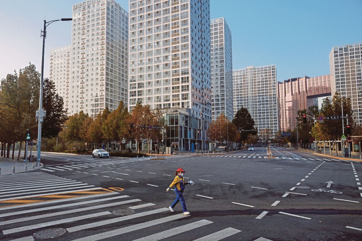 FOTO pada 23 November 2022 menunjukkan wanita menyeberang jalan yang lengang susulan lonjakan kes Covid-19 di Beijing, China. FOTO Reuters