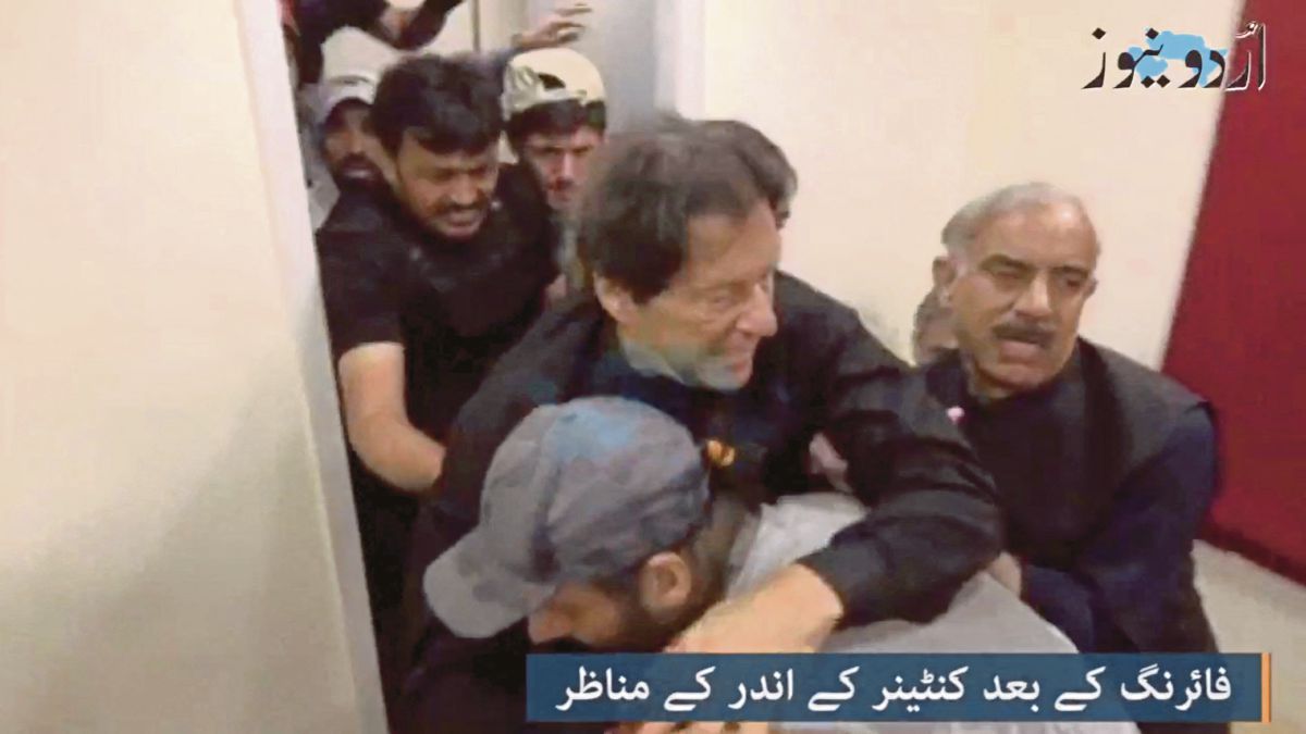 TANGKAP layar daripada video menunjukkan Imran Khan dibantu oleh beberapa individu selepas cedera akibat serangan berkenaan. FOTO Reuters 